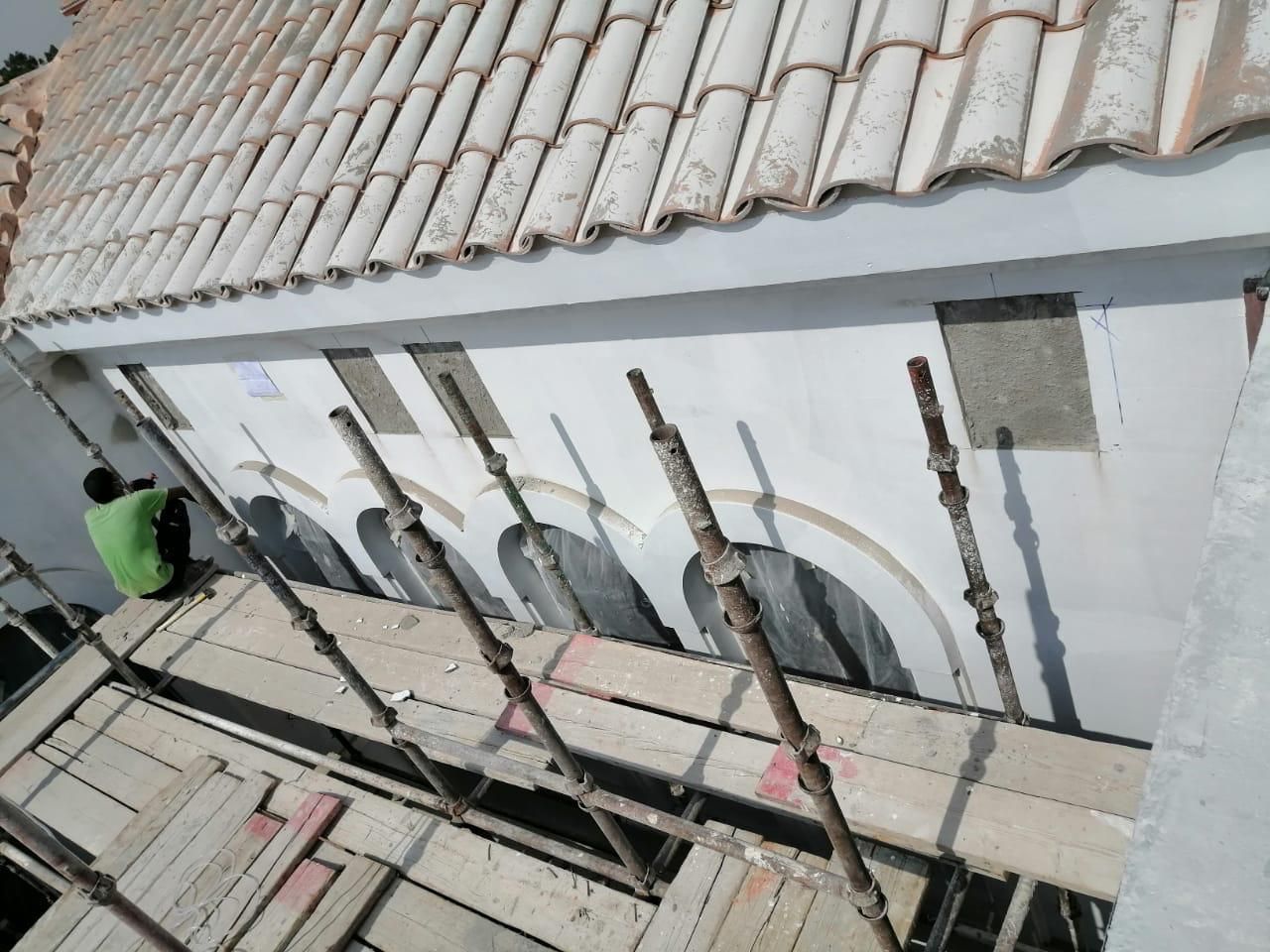 Façade under restoration beneath the clay tile roof
